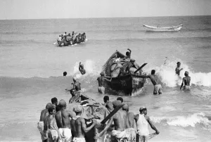 Canoeists of Lagos, Nigeria bringing goods from ships anchored off the coast