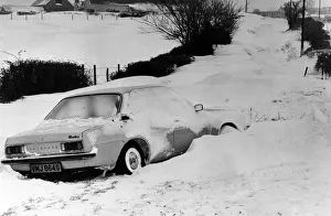 A car is left in a deep snow drift on the road from Culverhouse Cross to St Lythans near