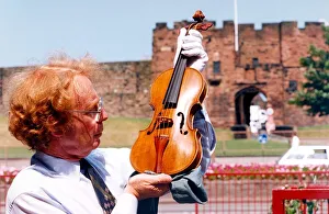 00117 Prints: Carlisles Tullie House Museum curator David Clark with a violin dated from 1565