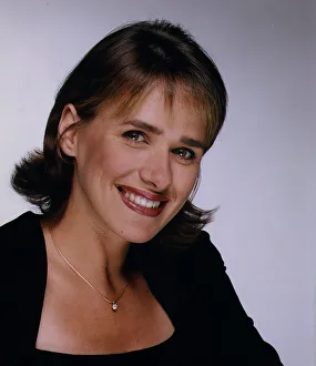 Carol Smillie TV presenter head shot in black square neck top bown feather cut hair