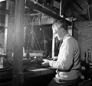 01186 Prints: Carpet Making Picture shows a man working on his loom. 1956