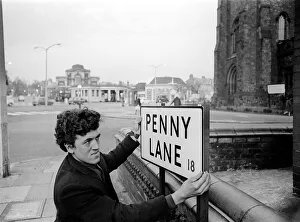 Core08 Prints: Bill Carrington holds Penny Lane Street Sign in Liverpool made famous by The Beatles
