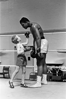 Cassius Clay with 6 year old Patrick Power in the ring during his training for