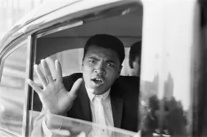 Portrait Posed Prints: Cassius Clay aka (Muhammad Ali) waves from his car after his arrival in London