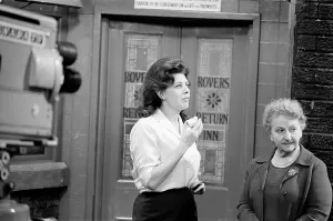 The cast of Coronation Street on set. Pat Phoenix eats an apple in a break
