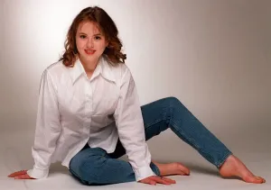 Catriona Evans sitting on floor wearing blue denims and white long sleeved blouse light