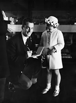 Celtic footballer Steve Chalmers signs an autograoh for a young fan at Abbotsinch Airport