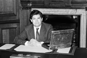 Chancellor of the Exchequer Nigel Lawson at his desk with the Budget case