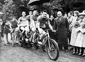 00078 Prints: At Chantilly racecourse these cyclists shelter under umbrellas while waiting to start