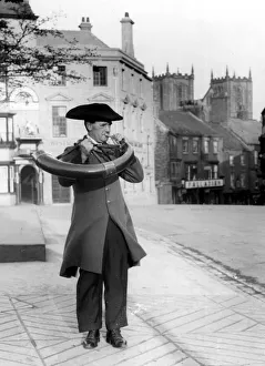Character Studies. Man wearing tricolor hat and cut Jacket blowing a horn in an unknown