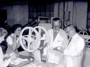 Checking soap as it comes warm from the moulding machine that stamps it into distinctive