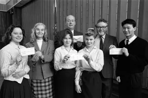 Cheques are presented to charity representatives at All Saints RC High School