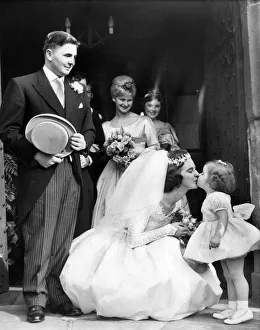 Cheryl Carmichael stands on tiptoes to receive a kiss from bride Wendy Emms