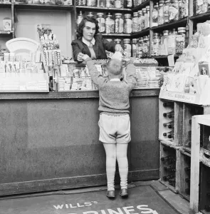 Child buying sweets at shop counter 9th April 1962