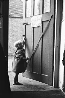 00993 Prints: Child closing the door to the classroom following morning break at Roxeth Primary School