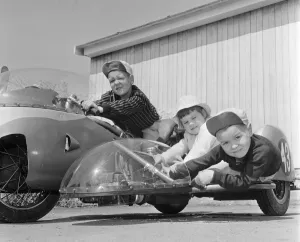Three children Brian, Carole Ann and Colin Digby sitting on their dad