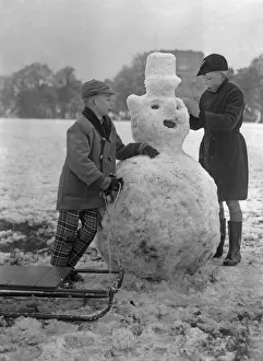 Sledge Prints: Children build a snowman in a Bristol park 31st December 1961