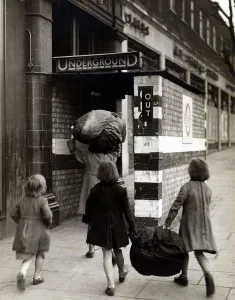 Baggage Prints: Children carrying bundles of laundry run towards the London Underground to take cover