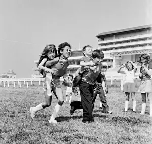 00585 Prints: Children carrying their partners on their backs during a horse and jockey style egg