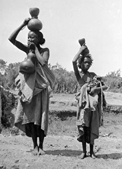 Nm20060306 Prints: Children carrying water jars on the banks of the Nile near to Cairo Circa 1935