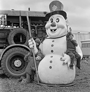 Winter Prints: Children climbing on large snowman figure at Silcocks Fair at Skelmersdale 17th May 1973
