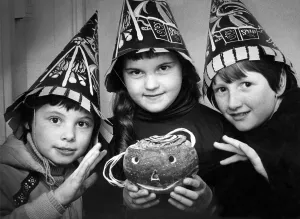 00107 Prints: Three children in costume with a turnip lantern for Halloween in October 1979