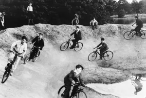 01479 Prints: Children cycling around a crater on a bomb site during Second World War. Circa 1944