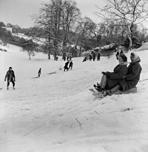 01358 Collection: Why should the children only have fun, as two women take part in sledging in Stoke Park
