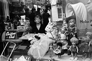 Children look longingly at toys into shop window at Christmas, 16th December 1960