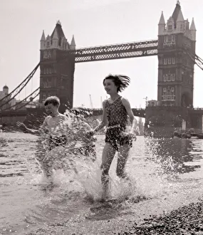 Splashing Prints: Children paddling on the foreshore below Tower Bridge July 1959