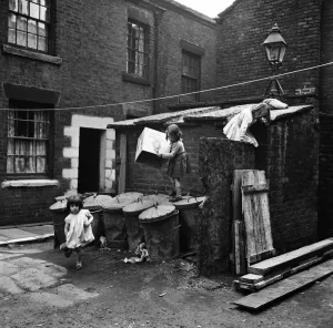 Children playing outside slum housing in Dickenson Street, Oldham. 1st June 1962