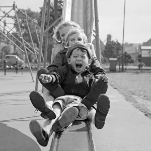 Slide Prints: Children playing smiling going down a slide chute September 1955 at Beeston Notts