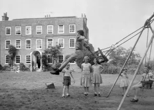 Swings Prints: Children playing on the swings at Beech Hill House convalescent home in Berkshire