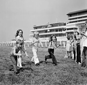 Images Dated 16th August 1973: Children race across the finish line of the egg and spoon race on the Downs at Epsom