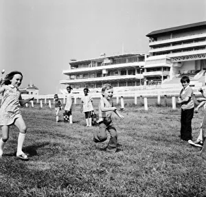 00585 Prints: Children race across the finish line of the egg and spoon race on the Downs at Epsom