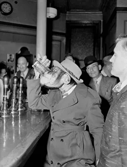 Chimp having a pint with his human friends at a pub - drinking beer May 1956