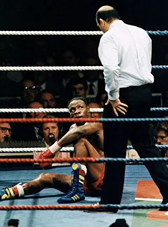 Chris Eubank boxer sitting exhausted in boxing ring as referee stand over him