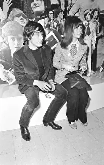 Christine Shrimpton with David Bailey. sitting in front of Photographic montage