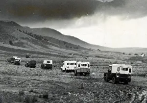 Mountain Prints: Churning through layers of mud, a line of Land Rovers move cross country towards