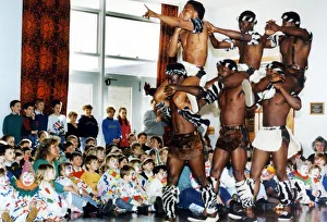 African Prints: Circus visits Redcar, children dressed as clowns watching performers from a circus