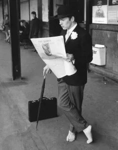Bowler Hat Prints: A city gent dressed in pin stripes, bowler hat and leaning on a brolley reads his copy of