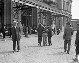 Casualty Prints: Two civilians help a wounded Belgian soldier to the railway station at Louvain
