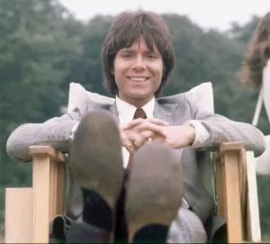 Cliff Richard seen here relaxing between takes on location filming for