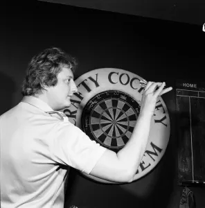 Close up feature on British darts player Eric Bristow in dart throwing action