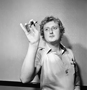 Close up feature on British darts player Eric Bristow in dart throwing action