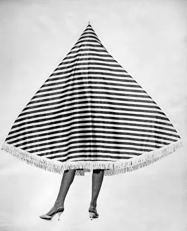 Clothing Beach 1963. Model Merril Weston wears a striped cape-tent