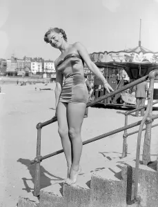 Holiday Prints: Clothing Beach wear swimsuits fashion April 1952 Model standing on steps wearing a