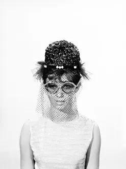 00061 Prints: Clothing: Fashion: Hats: Woman wearing hats with veils and glasses. 1962 B1544-033