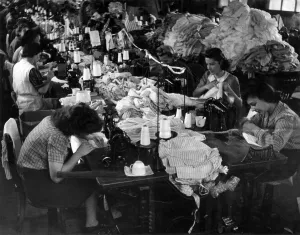 Production Line Prints: Clothing Industry: Girls at work sewing sleeves on to shirt in the sewing department