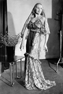 Clothing. Worth a million. Evening dress of gold lace with head dress of same material